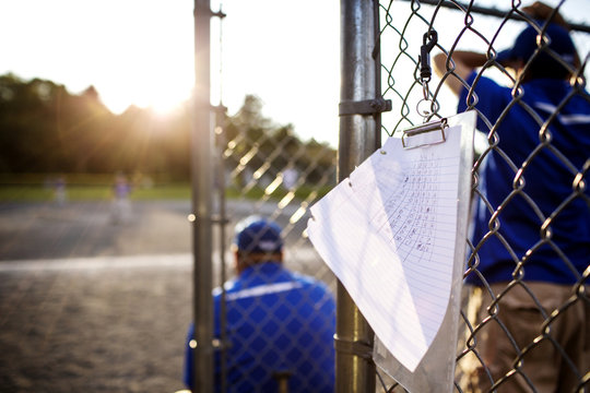 Score card hanging on fence with coach in background