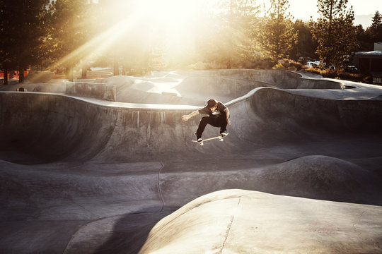 Skateboarder jumping in skatepark
