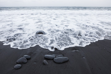 black volcanic stones and sand at the eastern coast of Tenerife, Canary Islands, Spain