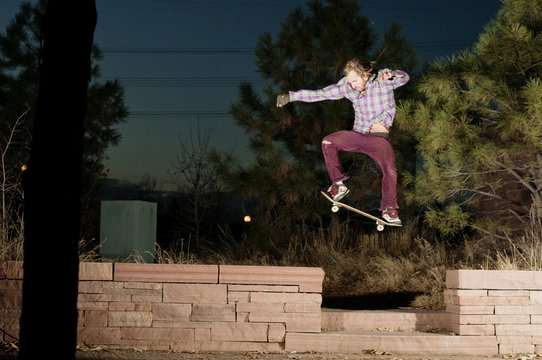 Young man jumping gap on skateboard