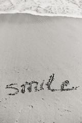 Abstract sign of word smile written, sand beach background