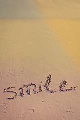 Abstract sign of word smile written, sand beach background