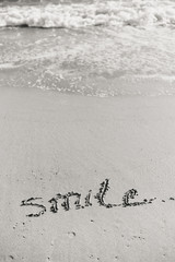 Abstract sign of word smile written, sand beach background