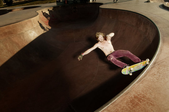 Skateboarder performing 5-0 Grid on pool coping