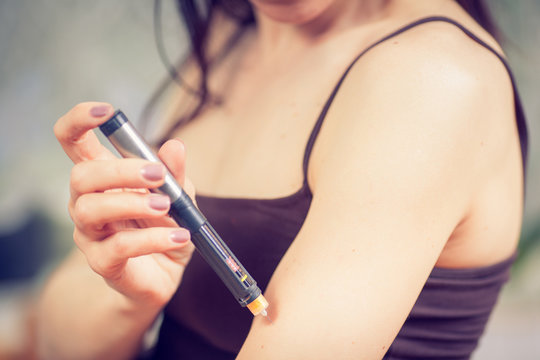 Picture of woman doing injection with insulin pen
