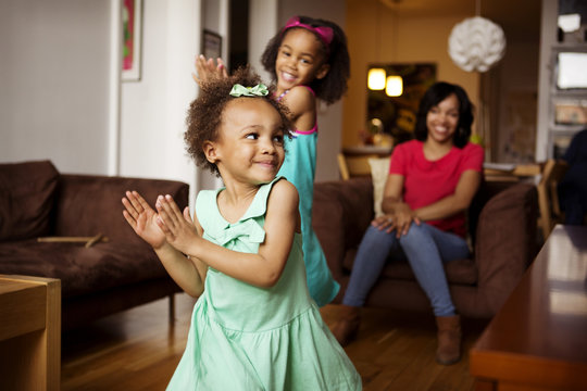 Smiling little girls dancing at home