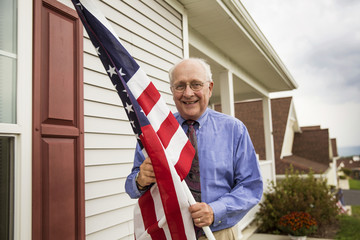 Smiling senior man holding American Flag