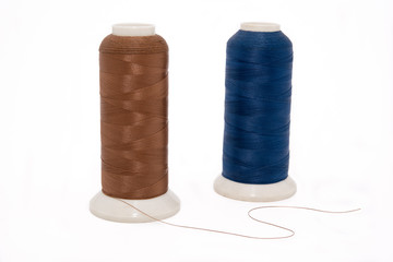Brown and blue threads on the white isolated background