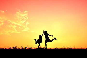Fototapeta na wymiar Silhouette children hands up in the sunset.Relax time