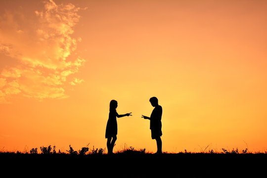 Silhouette children playing rock paper scisors