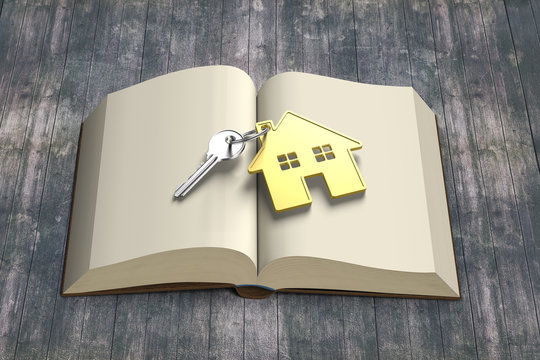 Golden house and key on top of opening book with old wooden tabl