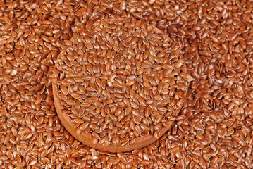 The flax seeds in a wooden bowl close up