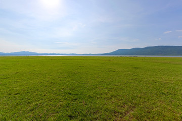 Landscape field of grass, sky and mountain.