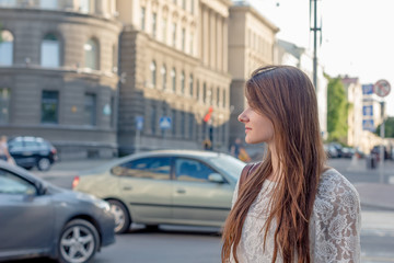 Naklejka na ściany i meble beautiful girl on a background of city streets at sunset