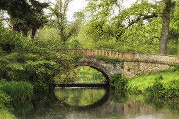 Fototapeta na wymiar Stunning landscape image of old medieval bridge over river with