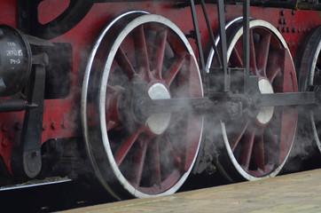 Red wheels of old black steam locomotive