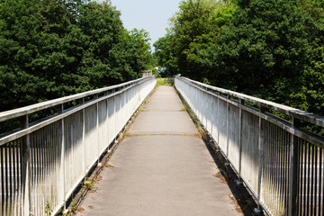 Obraz premium View along a long footbridge with railings on either side