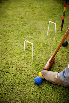 Cropped image of man playing croquet on grassy field