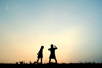 Silhouette children quarrel at sky sunset