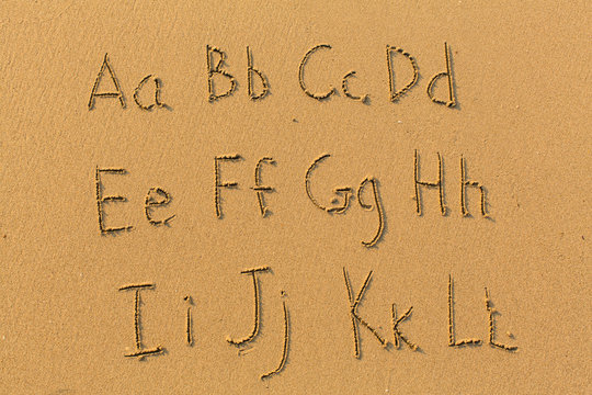Alphabet letters drawn on beach sand (A-L, 1/2)