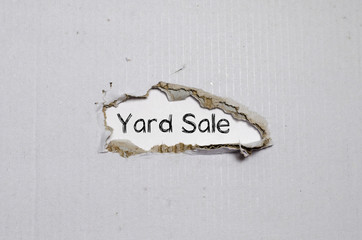 The word yard sale appearing behind torn paper.