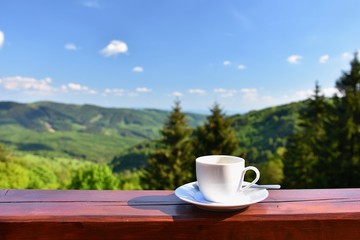 Morning cup of coffee with a beautiful mountain landscape background. Relaxation and recreation on...