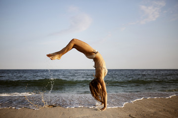 Woman doing backflip on beach