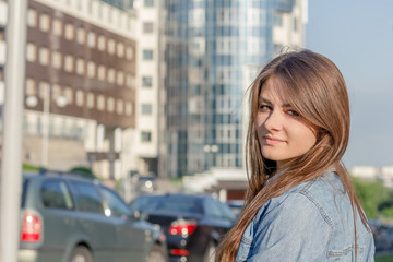 Fototapeta na wymiar beautiful girl on a background of city streets at sunset