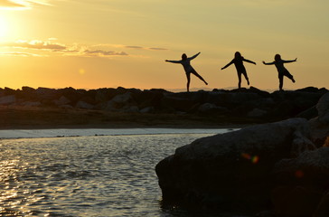 three women train by sunrise at sea