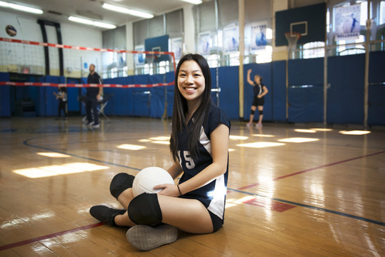 Portrait of a smiling woman sitting in a volleyball court