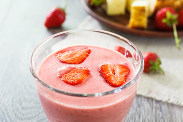 Glass of strawberry smoothie and cheesecake.