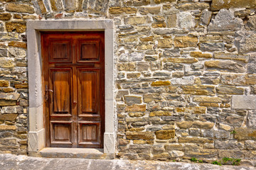 Mediterranean style wooden door on stone wall