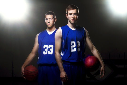 Portrait of two basketball players standing on court