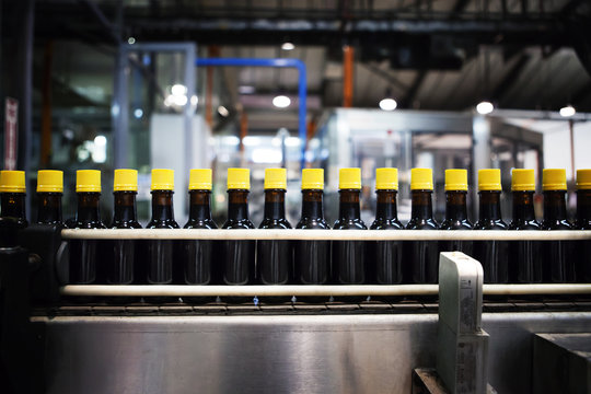 Glass bottle kept on machine for packaging in factory