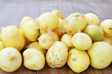 Heap of new potatoes over wooden table