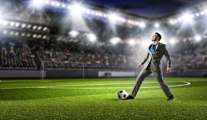 Businessman kicking ball