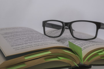 book with post it and reading glasses