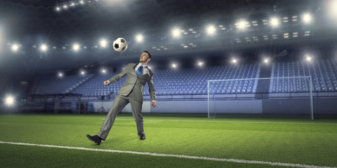 Businessman kicking ball