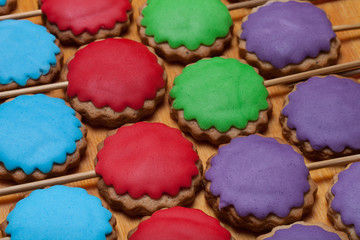 Gingerbread cookies with colored mastic on sticks on the old woo