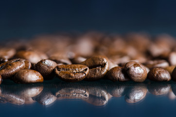 Coffee beans on a black background. Raw coffee beans. Grained product. Hot drink. Close up. Harvesting. Natural background. Energy. Reflection in a glass