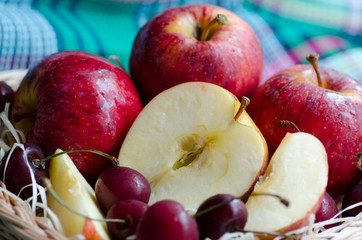 Red apples and cherry on a towel

