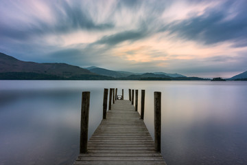 Wooden jetty leading out into lake with dramatic clouds in sky. Ashness, Derwentwater, Keswick, Lake District, UK. - obrazy, fototapety, plakaty