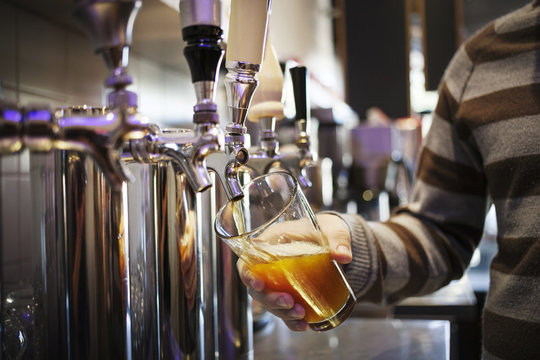 Close up of man pouring beer from tap