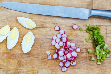 boiled eggs radish and green onion on a wooden board