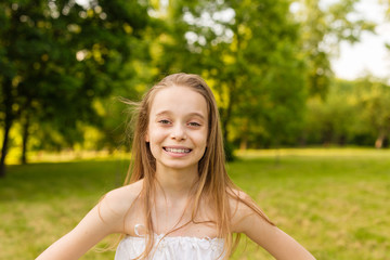 Outdoors portrait of beautiful young girl looking at you.