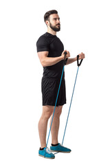 Young fitness athlete doing bicep curl arms exercise with resistance bands.  Full body length isolated over white studio background.