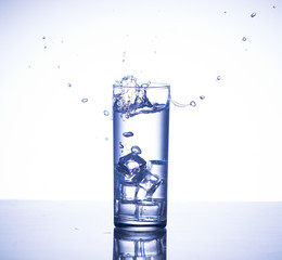 Ice cube makes splash into glass of water