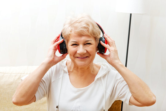 Happy senior woman wearing red headphones
