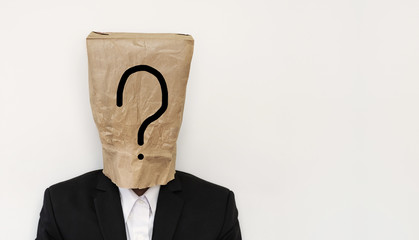 Businessman with brown paper bag on head, with question mark symbol with copy space, on white...