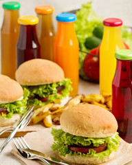 Burger with beef, tomato and herbs. Fries and juice.